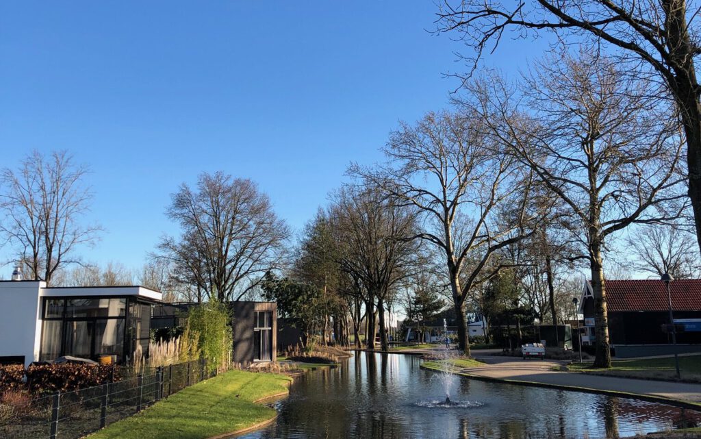 Ferienhaus im EuroParcs Bad Hoophuizen am Veluwemeer in Holland mit Bäumen und Wasserfläche